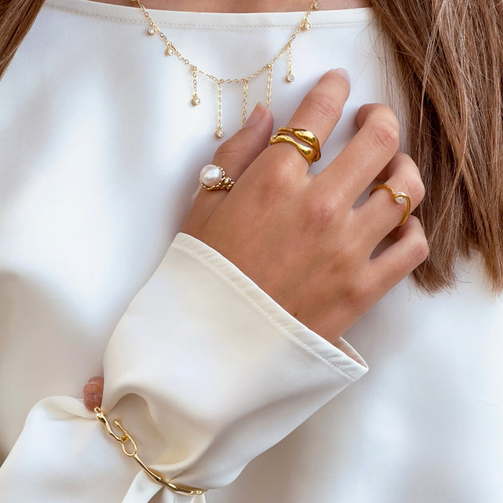 Aqua Dulce Wave Ring i forgyldt ses på hånd med andre ringe, elegant og organisk design. Model 6626-001