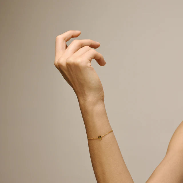 enamel-four-leaf-clover-armband-i-forgyldt-solv bæres på håndled, tyndt kædearmbånd i guldlook med lille kløver detalje. Model b148gm-2