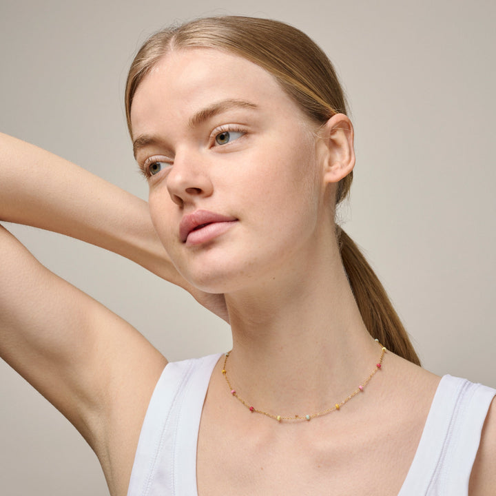 Enamel Lola Bold halskæde Rainbow i forgyldt sølv med farverige perler, båret af model. Model n137g-rainbow-2