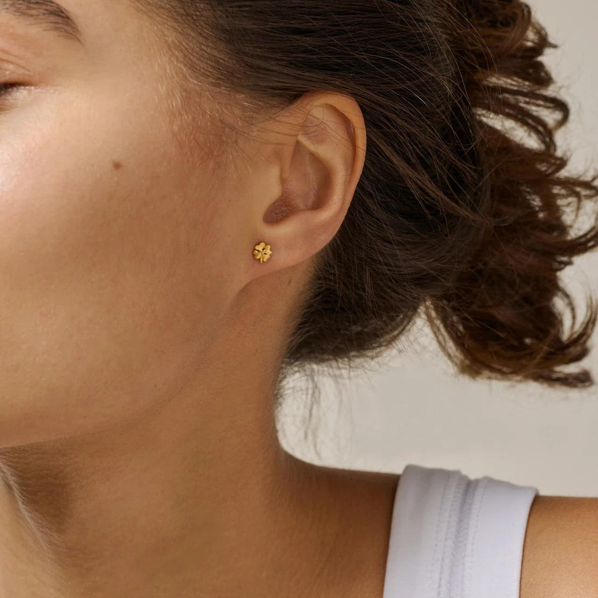 Enamel Organic Clover sma firekløver ørestikker i forgyldt vises båret på øre, Model E412GM-1.