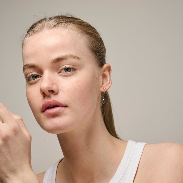 Enamel Sunshine Drop Earrings Daisy e423g-daisy vises på model, diskrete guld øreringe med lille blomst og dråbe. Model e423g-daisy-2.