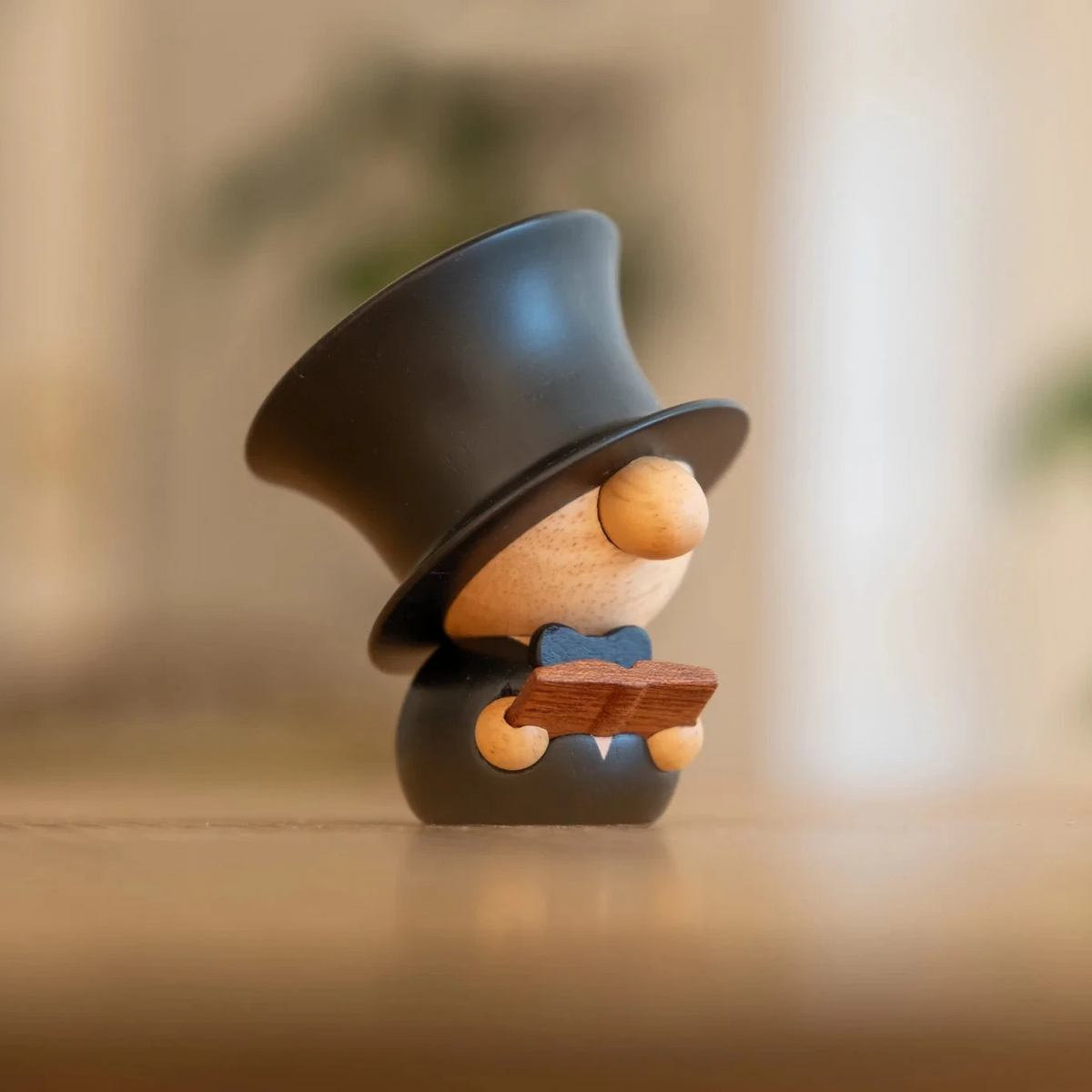 FableWood H.C. Andersen Figur i træ med sort høj hat og bog, stående på bord, Model 8001-1