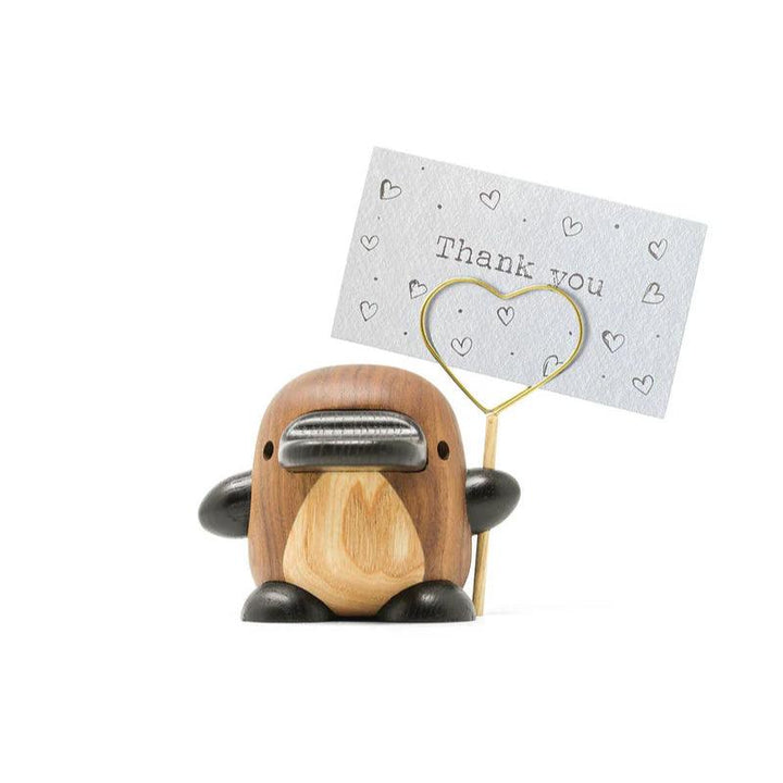 Fablewood Næbdyret Perry viser en dekorativ træfigur i brune nuancer med metalskilt, Model 1403-2.