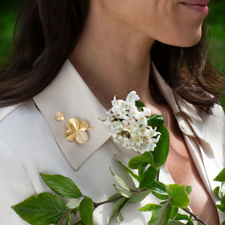 Flora Danica Firklover Pin Pavé Forgyldt ses båret på en lys skjorte, gylden detalje med sten. Model 907-flc-pi-g-pave-2