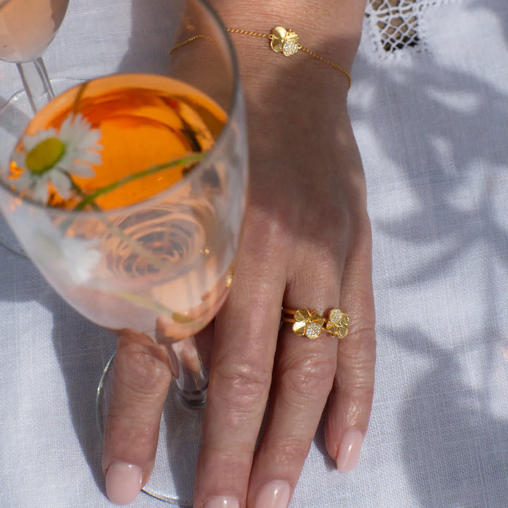 Flora Danica Firklover Ring Pavé Forgyldt viser elegant guldfarvet ring med firkløver-design på hånd. Model 907-flc-ri-g-pave-001-2