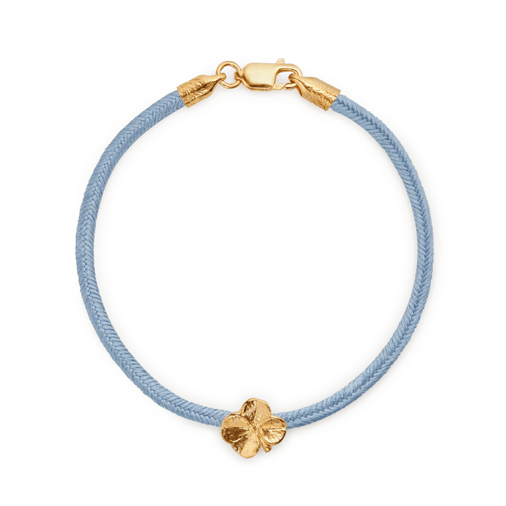 Flora Danica Firklover Silke Armbånd Blå Forgyldt vist tæt på med blå silkesnor og firkløver charm i guld. Model907-flc-silk-blue-g-001-1.