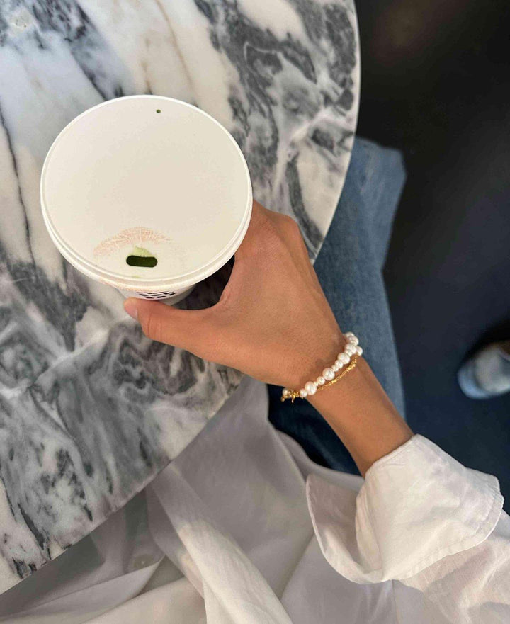 Hultquist Copenhagen Josephine armbånd med hvide perler og gulddetaljer bæres på hånd, Model S08559G-2.