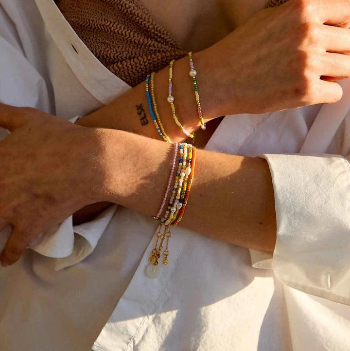 Hultquist Copenhagen Paisley Perle Armbånd med farvede perler og perledetaljer på kvindearm i sollys. Model S08619G-2