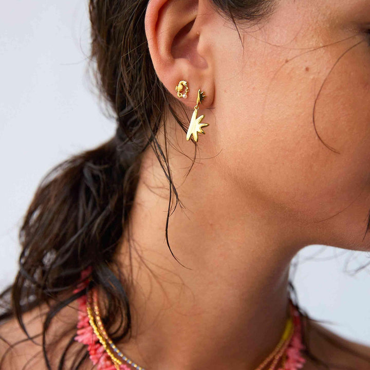 Hultquist Sandy øreringe forgyldt vises på kvindes øre med stjerneformet detalje. Model S08497G-2