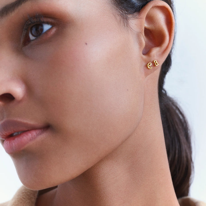 Maanesten Alphabet Single Bogstav Ørestik AW I forgyldt vises båret i øret, elegant guldlook. Model 101a-alphabet-001-1