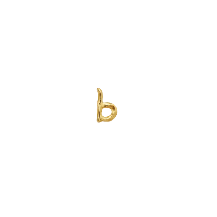 Maanesten Alphabet Single Bogstav Ørestik AW i forgyldt viser et lille b-formet, gyldent smykke på sort baggrund. Model 101a-alphabet-002-3