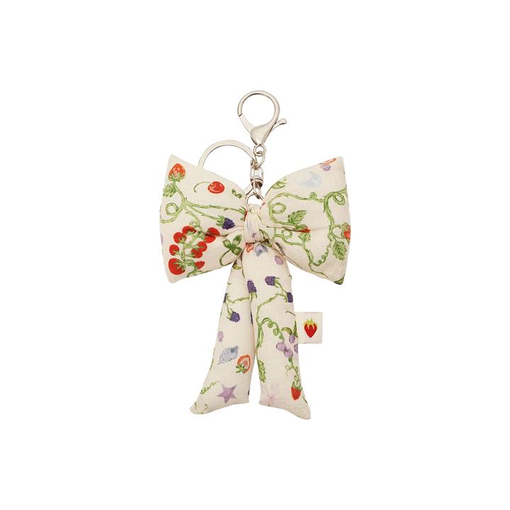 Maanesten Fabric Bow Nøglering Garden Magic Ivory viser en stor stofsløjfe med blomsterprint og sølv farvet nøglekrog. Model 4111