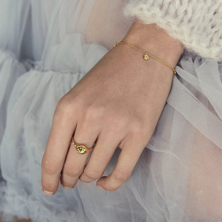 Maanesten Lysander forgyldt armbånd vises på hånd i feminin, lys vams og tyl. Model 8691a-2