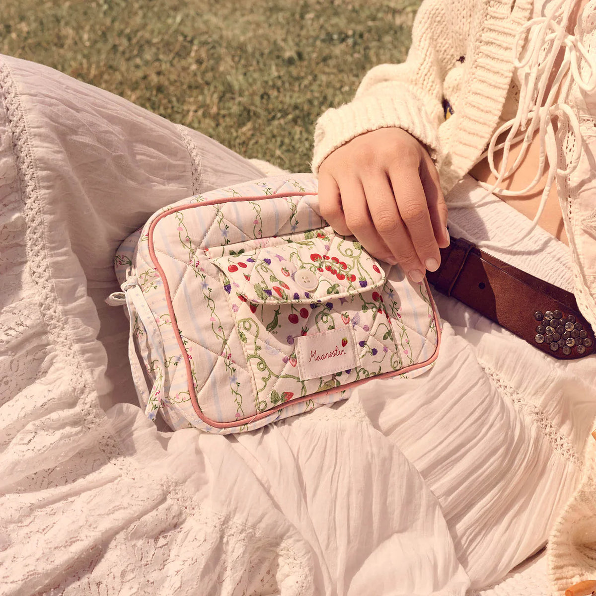 Maanesten Reva Bag Summer Stripes Blue vises her i quiltet bomuld med blomstermønster, båret på hvid kjole. Model 4131-1