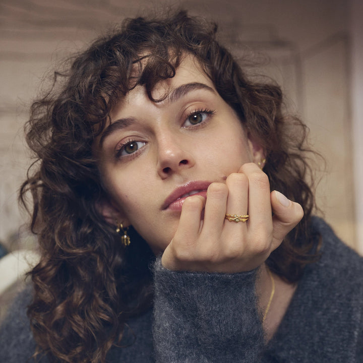 Maanesten Ria Forgyldt Ring vises på kvindes hånd, bølget design i guld-look, Model 4873a-001