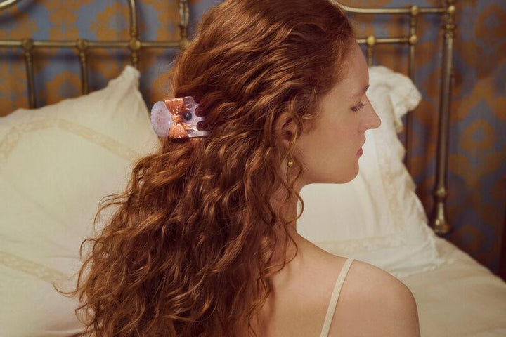 maanesten-ruku-hair-claw-dawn i lilla og rosa akryl ses i langt, bølget hår på kvinde. Model3972-2