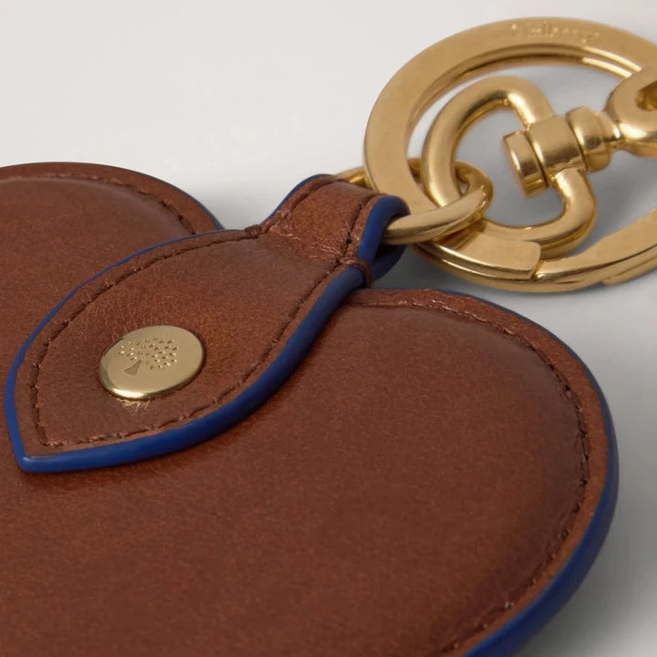 Mulberry Heart Keyring Oak/Pigment Blue viser et nøglevedhæng i brunt læder med blå kant og guldfarvet lås, Model rk6003562g231.