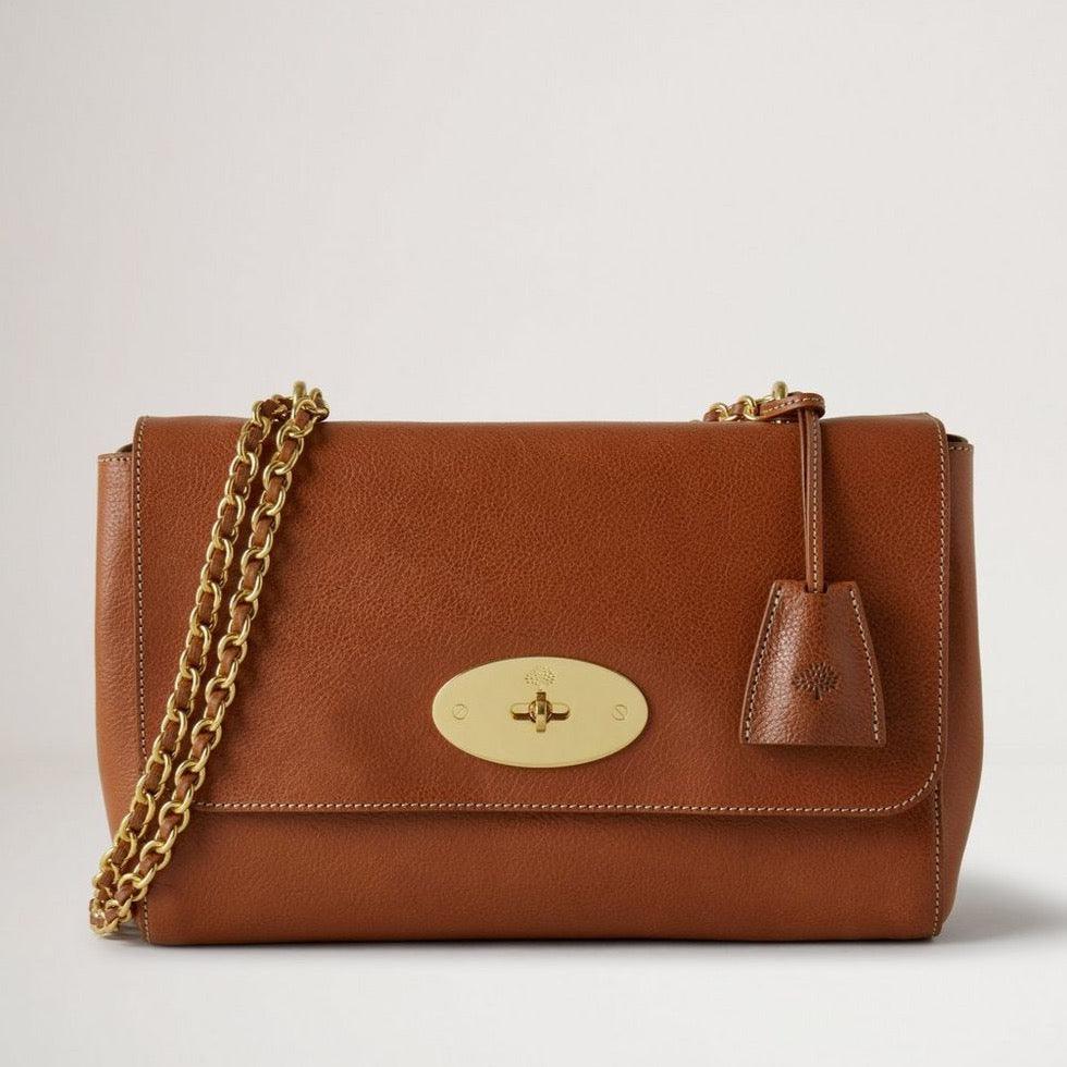 Mulberry Medium Lily Legacy NVT Oak viser en mellemstor brun lædertaske med kæderem og guldfarvet lås. Model HH7944275G110.
