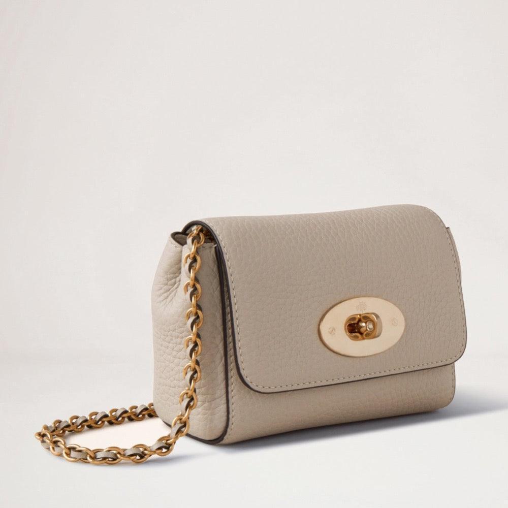 Mulberry Mini Lily Heavy Grain Chalk viser en lille, beige skuldertaske i kraftigt læder med kæderem og gyldent låsespænde. Model RL7944736W160.