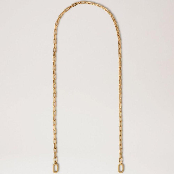 Mulberry Softie Chain Crossbody Strap i blank messingfarvet metal, elegant kæde mod lys baggrund. Model RX0289000N188