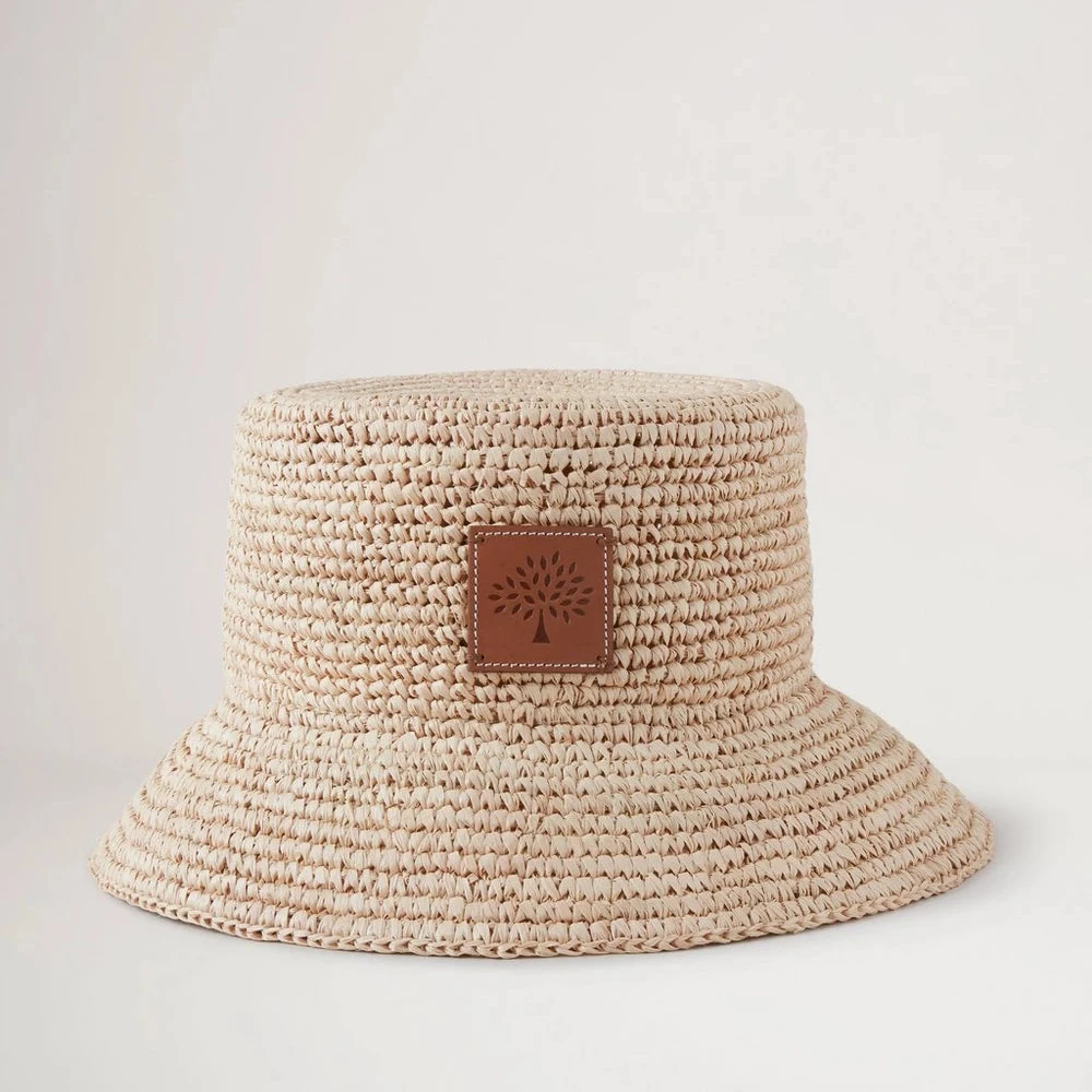 Mulberry Summer Raffia Bucket Hat viser en lys, flettet sommerhat i raffia med læderdetalje foran. Model VH4097807H120