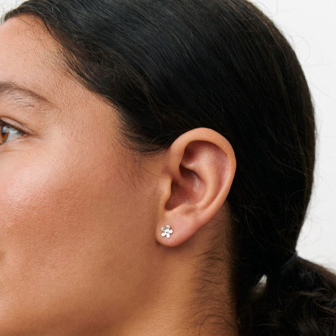 Pernille Corydon Mini Wild Poppy ørestikker viser et sølv blomsterformet ørering på model. Model E-369-S