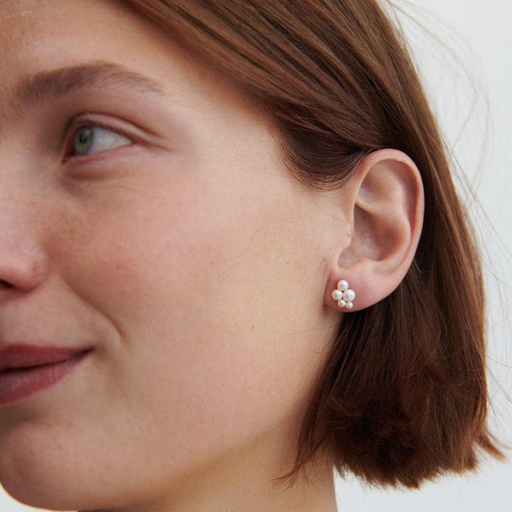 Pernille Corydon Ocean Bay forgyldte perle øreringe bæres tæt på øret, feminine hvide perler. Model E-442-GP-2.