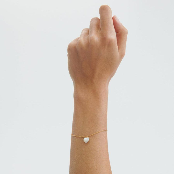 Pernille Corydon Ocean Heart forgyldt armbånd vist på håndled med hvid hjertevedhæng, Model B-387-GP