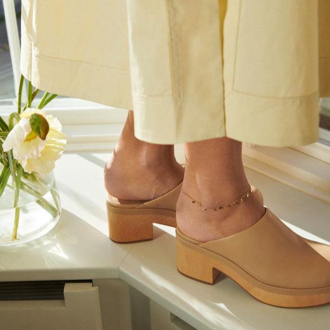 Pernille Corydon Sheen forgyldt ankelkæde bæres på anklen, set i sollys med beige sko. Model A-315-GP-1