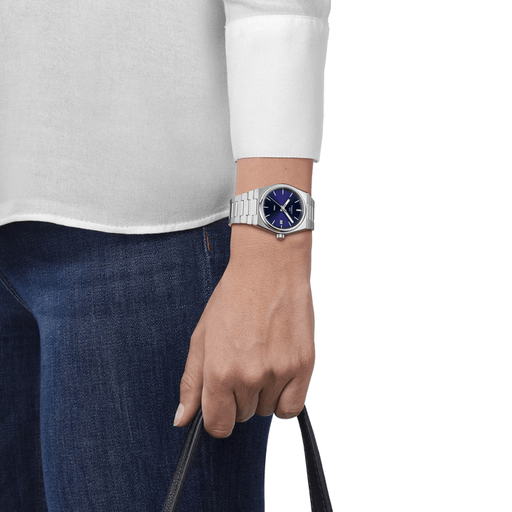 Tissot PRX med blå urskive ses på håndled, stål lænke og casual stil, Model T1372101104100.