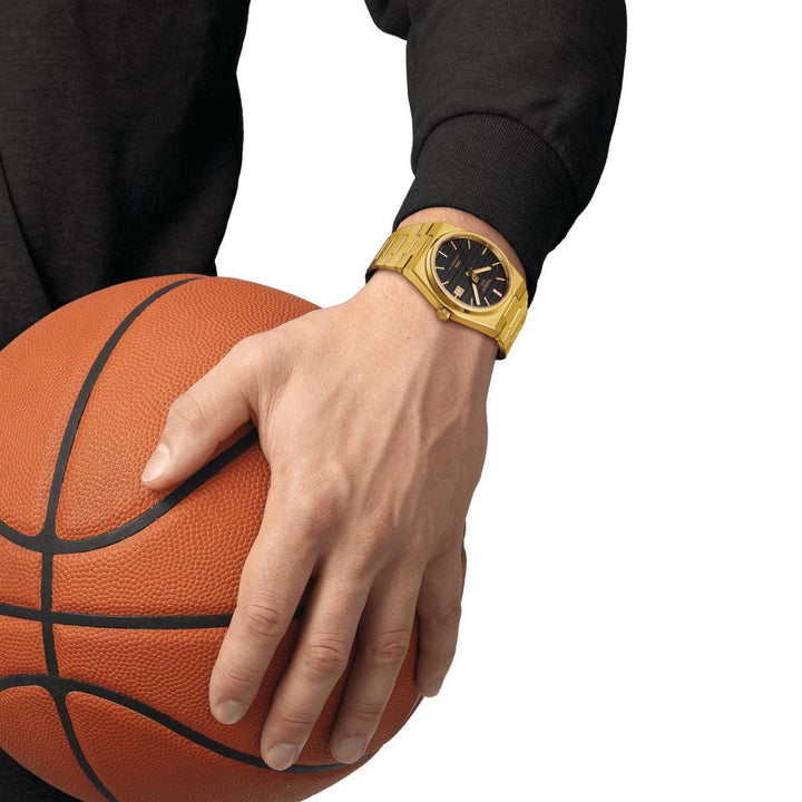 Tissot PRX Powermatic 80 Damian Lillard Special Edition bæres på hånd med basketball, guldfarvet ur. Model T1374073305100