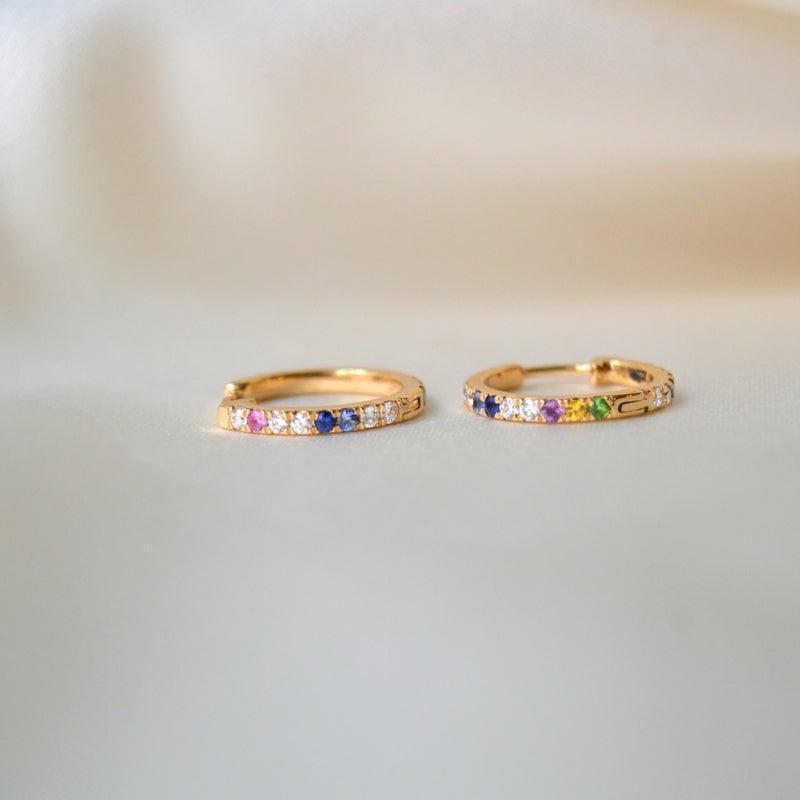 anpe atelier kyra creoler 18kt guld m brillianter og ædelstene, to øreringe med farvede sten liggende på lys baggrund. Model 23-2-customized-1