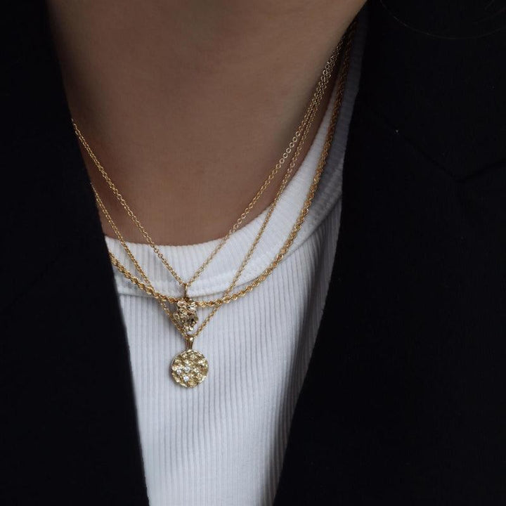 Jeberg Jewellery I Am Gold Petite Halskæde bæres om halsen med rund, mønstret vedhæng i guld. Model 40760-2