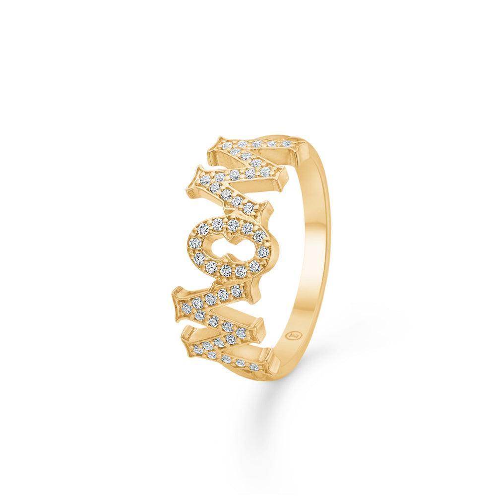 Mads Z 14kt Wowmom Ring 0.23ct W/SI viser en guldring med WOWMOM bogstaver besat med diamanter. Model 1541099-001-1