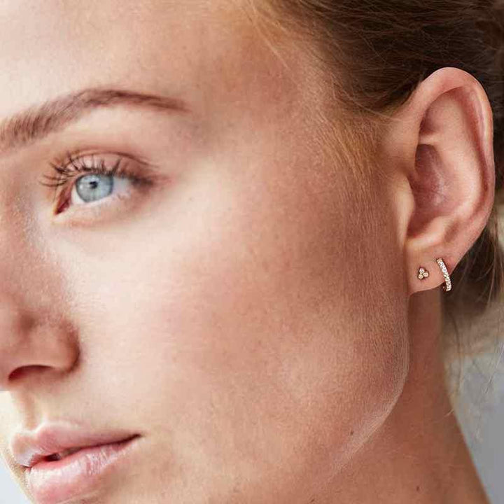 Ro Copenhagen 18kt Orbit Dot ørestik vist på øret, elegant design i guld med små diamanter. Model 119120-2